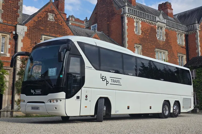 Leap Travel 55-seat Tourliner coach outside a red-brick country house
