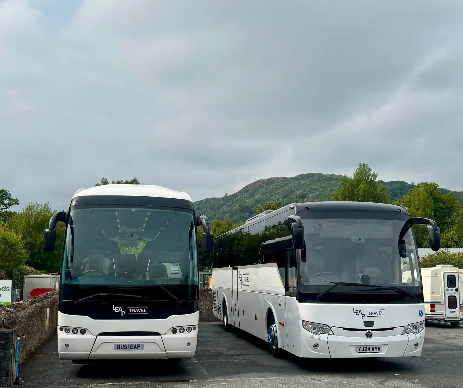 Two Leap Travel coaches parked by Lake Windermere